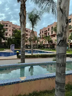 a swimming pool in a resort with palm trees at appartement à coté des palmeraies in Marrakech