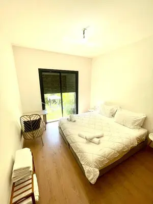 a bedroom with a large bed and a window at Ana cosy - Clim, Wifi, Jardin à 10min de l'Aéroport in Marrakech
