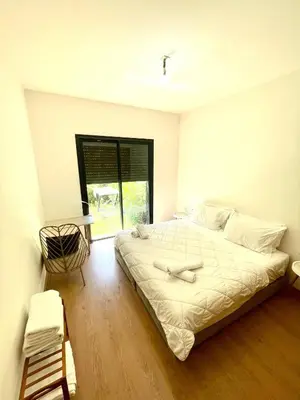 a bedroom with a large bed and a window at Ana cosy - Clim, Wifi, Jardin à 10min de l'Aéroport in Marrakech