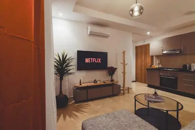 a kitchen with a tv on the wall at Eva cosy - Clim, Wifi, Jardin à 10min de l'Aéroport in Marrakech