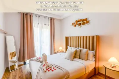 a bedroom with a large bed with two dolls on it at Lina cosy - Clim, Wifi, Jardin à 10min de l'Aéroport in Marrakech