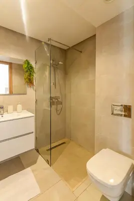 a bathroom with a shower and a toilet and a sink at Maeva cosy - Clim, Wifi, Jardin à 10min de l'Aéroport in Marrakech