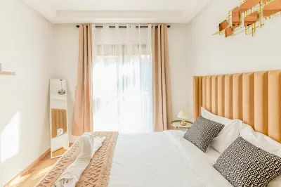 a bedroom with a bed and a window at Maeva cosy - Clim, Wifi, Jardin à 10min de l'Aéroport in Marrakech