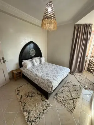 a bedroom with a large bed and a chandelier at Dali apartment in Marrakech