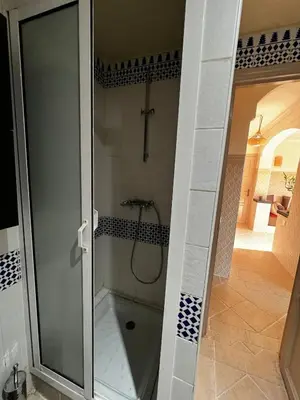 a shower with a glass door in a bathroom at Dali apartment in Marrakech