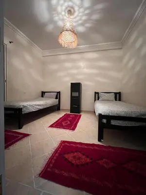 a room with two beds and a chandelier at Dali apartment in Marrakech