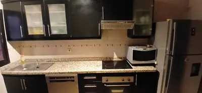 a kitchen with a stove and a refrigerator at Gueliz apartment 2 chambres Marrakech in Marrakech