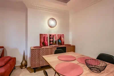 a dining room with a table and red chairs at La Kasbah - 2bdr- Parking - Wifi - Terrasse in Marrakech
