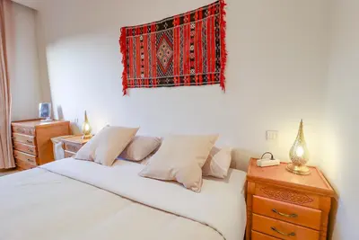 a bedroom with a bed and a rug on the wall at La Kasbah - 2bdr- Parking - Wifi - Terrasse in Marrakech