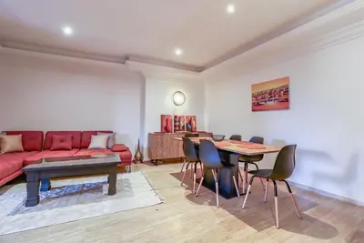 a living room with a red couch and a table at La Kasbah - 2bdr- Parking - Wifi - Terrasse in Marrakech
