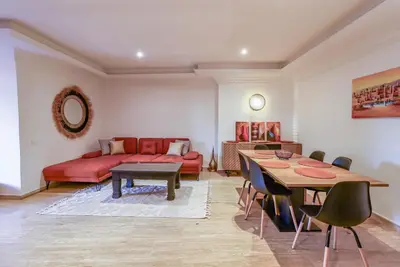 a living room with a red couch and a table at La Kasbah - 2bdr- Parking - Wifi - Terrasse in Marrakech