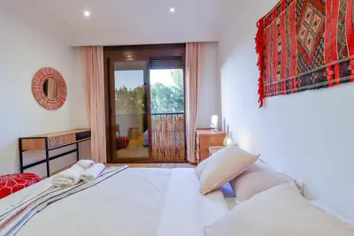 a bedroom with a bed and a large window at La Kasbah - 2bdr- Parking - Wifi - Terrasse in Marrakech