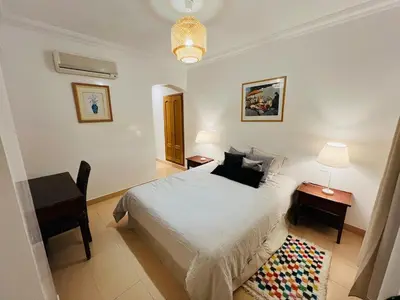 a bedroom with a bed and a table and a desk at Appartement Centre de Gueliz in Marrakech