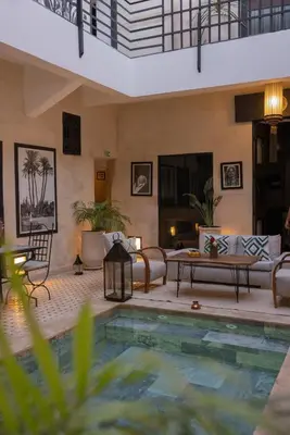 a pool in a living room with a couch and a table at Riad Dar Bousga in Marrakech