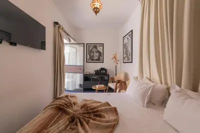 a bedroom with a bed and a room with a desk at Riad Dar Bousga in Marrakech