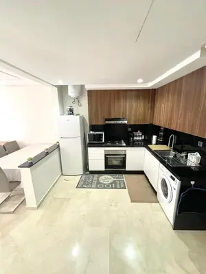a kitchen with a white refrigerator and a dishwasher at Mama cosy - Clim, Wifi, Piscine en centre ville in Marrakech