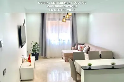 a living room with a couch and a table at Mama cosy - Clim, Wifi, Piscine en centre ville in Marrakech
