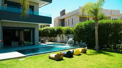 a yard with chairs and a swimming pool in a house at Villa contemporaine in Marrakech