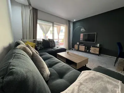 a living room with a couch and a tv at Appartement familial in Marrakech