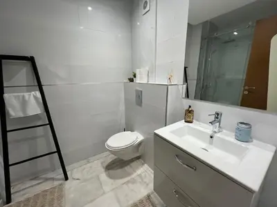 a white bathroom with a toilet and a sink at Appartement familial in Marrakech