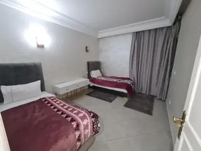 a hotel room with two beds and a window at résidence ATLASS in Marrakech