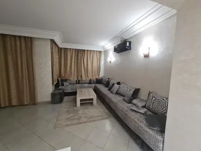 a living room with a long couch and a table at résidence ATLASS in Marrakech