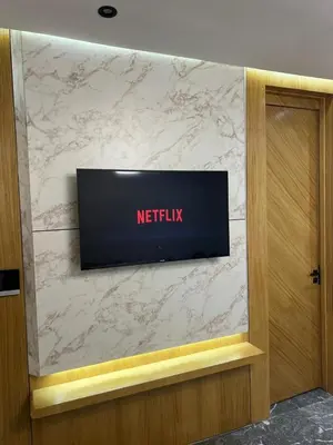 a television on top of a marble wall at elite garden appartment in Marrakech