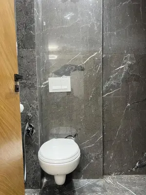 a bathroom with a toilet in a marble wall at elite garden appartment in Marrakech