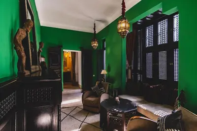 a living room with green walls and a couch at Riad El Ayadi, Moorish villa in Marrakech