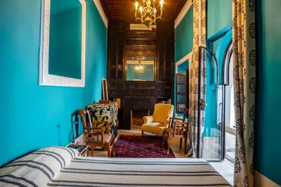 a living room with blue walls and a chandelier at Riad El Ayadi, Moorish villa in Marrakech