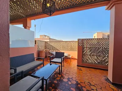 a patio with benches and chairs on a balcony at Résidence la paix in Marrakech