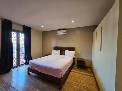 a bedroom with a bed and a large window at Résidence la paix in Marrakech