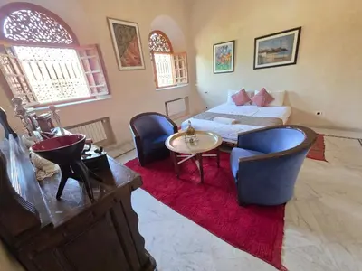a living room with a bed and a table and chairs at Abraj Bladi Resort in Marrakech