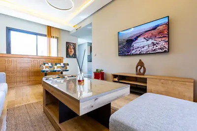 a living room with a tv on the wall at Central Marrakesh Apartment in Marrakech
