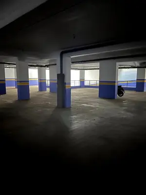 an empty parking garage with a motorcycle parked in it at Central Marrakesh Apartment in Marrakech