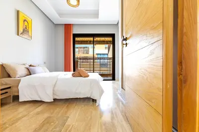 a bedroom with two beds and a sliding door at Central Marrakesh Apartment in Marrakech