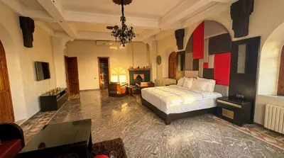 a large bedroom with a bed and a living room at Charming Luxury Villa - Pool & Hot Tub in Marrakech