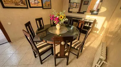 a dining room table and chairs with a vase of flowers on it at Charming Luxury Villa - Pool & Hot Tub in Marrakech