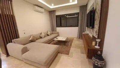 a living room with a couch and a tv at Appartement proche Gueliz in Marrakech
