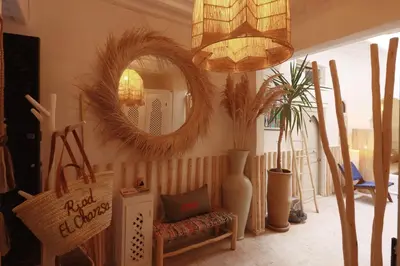 a living room with a chair and a mirror at Riad El Charsa, logement entier 4 à 6 personnes, proche Jemaa El Fna, Rooftop et bassin chauffé in Marrakech