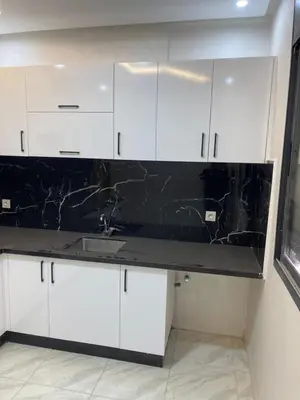 a kitchen with white cabinets and a black counter top at Dar l7aj Brahim in Marrakech
