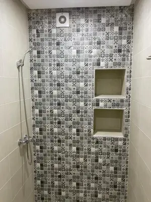 a bathroom with a shower with a tiled wall at Dar l7aj Brahim in Marrakech
