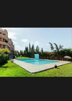a large swimming pool in the middle of a yard at Appartement moderne à 5piscines in Marrakech