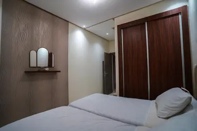 a bedroom with two beds and a wooden headboard at New and luxurious apartment with a pool in Marrakech