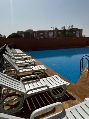 a row of lounge chairs next to a swimming pool at New and luxurious apartment with a pool in Marrakech