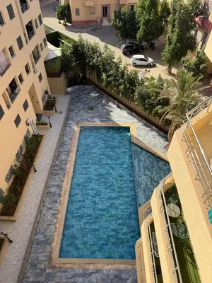 an overhead view of a swimming pool between two buildings at Burj Malak appartement pour les familles in Marrakech