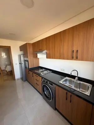 a kitchen with a sink and a stove at Burj Malak appartement pour les familles in Marrakech