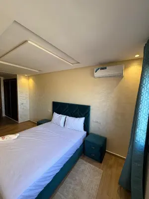 a bedroom with a large bed and a air conditioner at Burj Malak appartement pour les familles in Marrakech