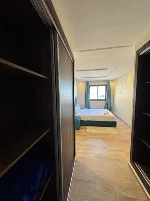 a room with a bed and a room with a closet at Burj Malak appartement pour les familles in Marrakech