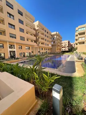 a large building with a swimming pool in front of it at Palmeraie Appart B4 Piscine & Parking in Marrakech